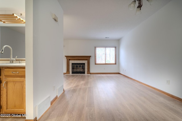 1976 Curry Rd Unit E-136, Schenectady, NY 12303 - unfurnished living room featuring a sink, light wood-type flooring, a fireplace, and baseboards