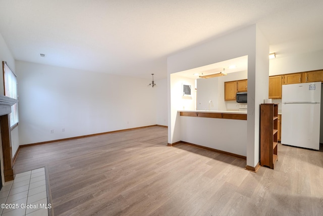 1976 Curry Rd Unit E-136, Schenectady, NY 12303 - unfurnished living room with light wood finished floors, a sink, baseboards, and a fireplace with flush hearth