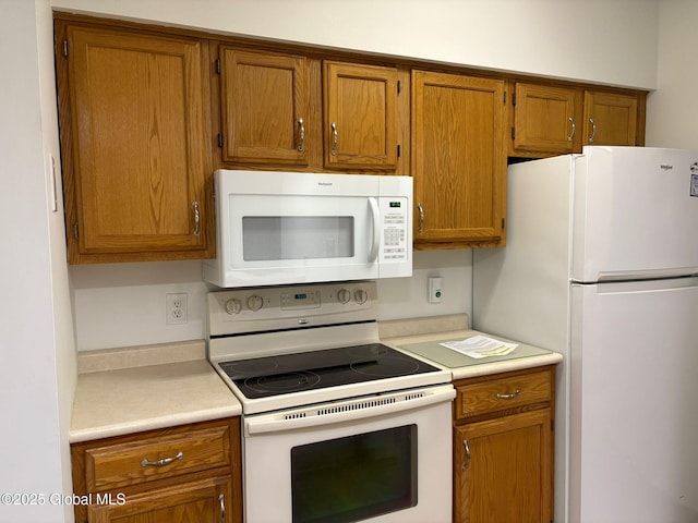 1976 Curry Rd Unit E-136, Schenectady, NY 12303 - kitchen featuring white appliances, light countertops, and brown cabinetry