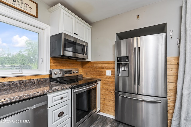 2044 Caldicott Rd, Rotterdam, NY 12303 - kitchen featuring appliances with stainless steel finishes, wood walls, white cabinetry, dark wood-style floors, and dark stone countertops