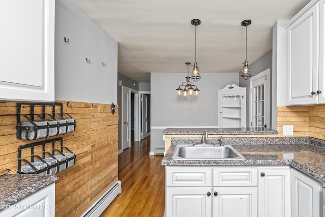 2044 Caldicott Rd, Rotterdam, NY 12303 - kitchen with a sink, light wood-style flooring, white cabinets, a baseboard radiator, and wooden walls
