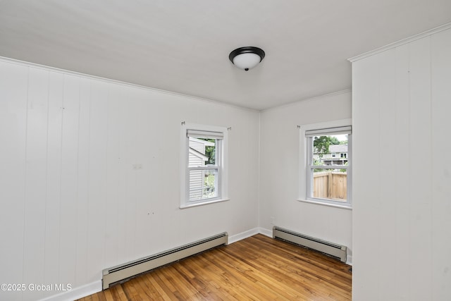 2044 Caldicott Rd, Rotterdam, NY 12303 - spare room featuring a baseboard heating unit, plenty of natural light, wood-type flooring, and crown molding