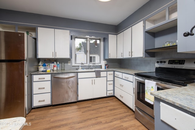 184 Main St, South Glens Falls, NY 12803 - kitchen with appliances with stainless steel finishes, a sink, open shelves, and white cabinetry