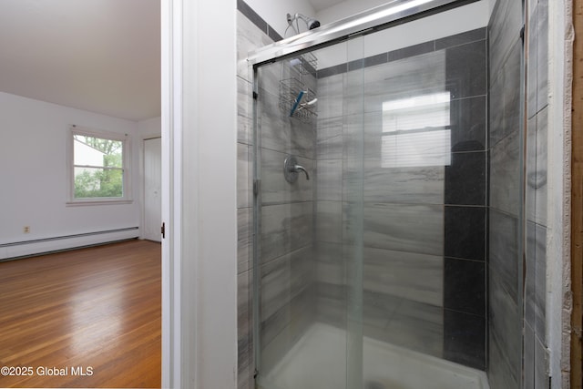 184 Main St, South Glens Falls, NY 12803 - full bathroom featuring a shower stall, baseboard heating, and wood finished floors