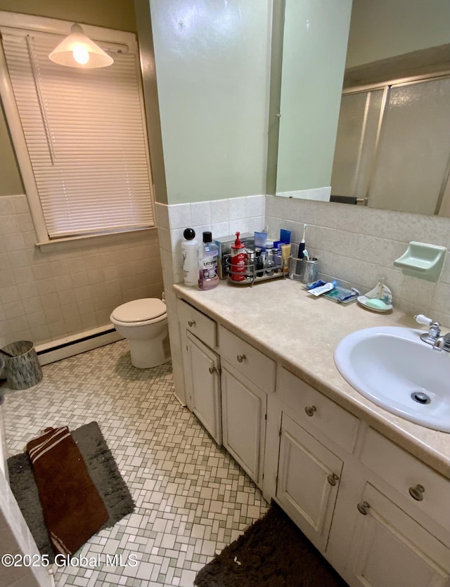 6 Kenyon Dr, Colonie, NY 12205 - bathroom with baseboard heating, tile walls, a stall shower, vanity, and wainscoting