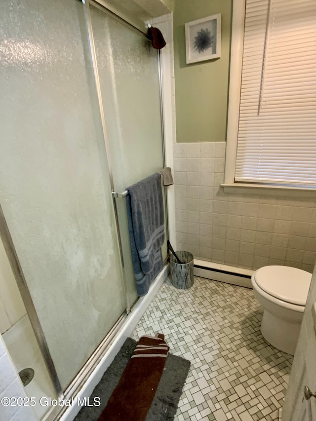 6 Kenyon Dr, Colonie, NY 12205 - bathroom with baseboard heating, a shower stall, tile walls, toilet, and wainscoting