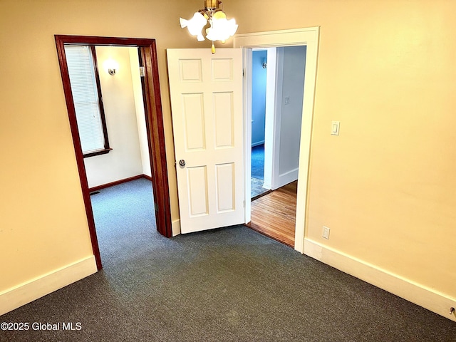 2618 Stanton St, Rotterdam, NY 12306 - unfurnished room with a chandelier, dark carpet, and baseboards