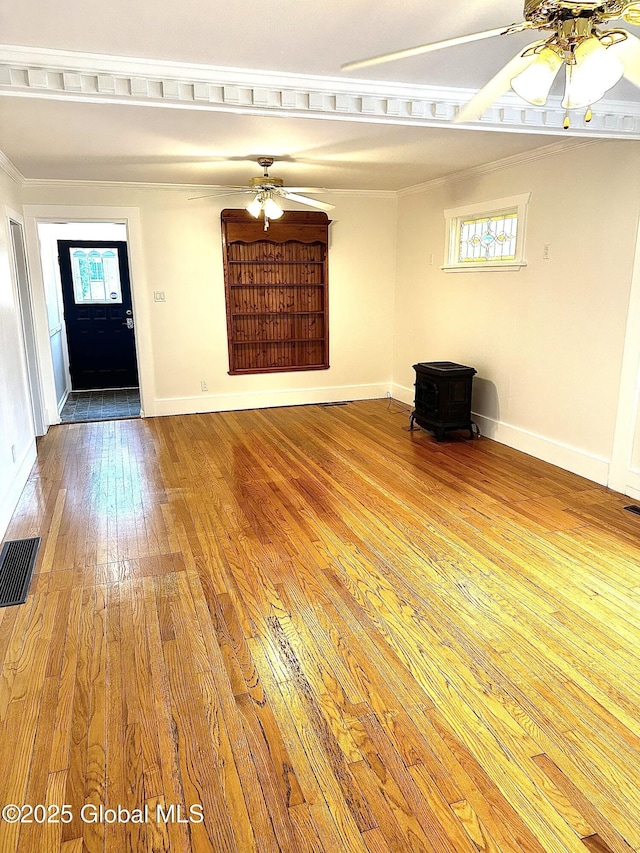 2618 Stanton St, Rotterdam, NY 12306 - unfurnished living room with a wood stove, ceiling fan, hardwood / wood-style flooring, crown molding, and baseboards