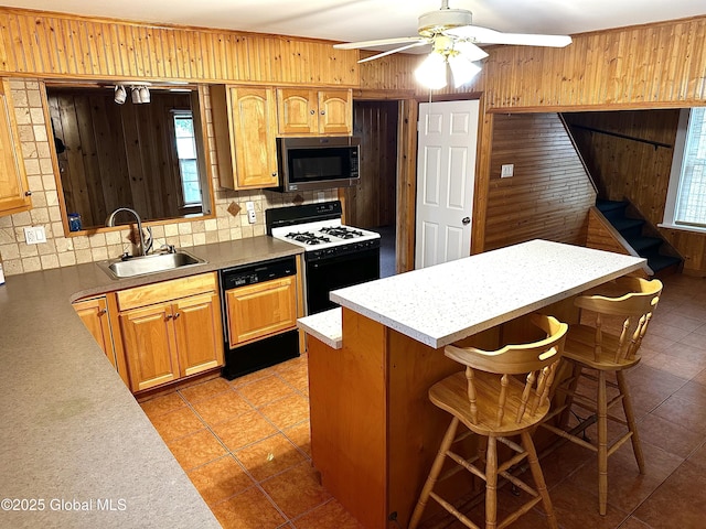 2618 Stanton St, Rotterdam, NY 12306 - kitchen with stainless steel microwave, dishwasher, gas stove, wood walls, and a sink