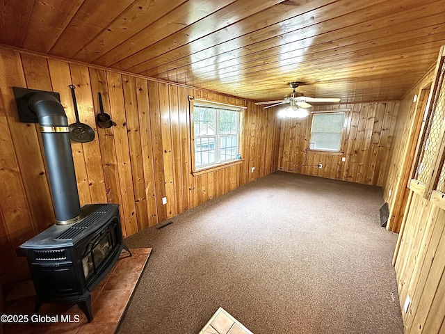 2618 Stanton St, Rotterdam, NY 12306 - unfurnished living room with wood ceiling, a wood stove, carpet floors, ceiling fan, and wooden walls