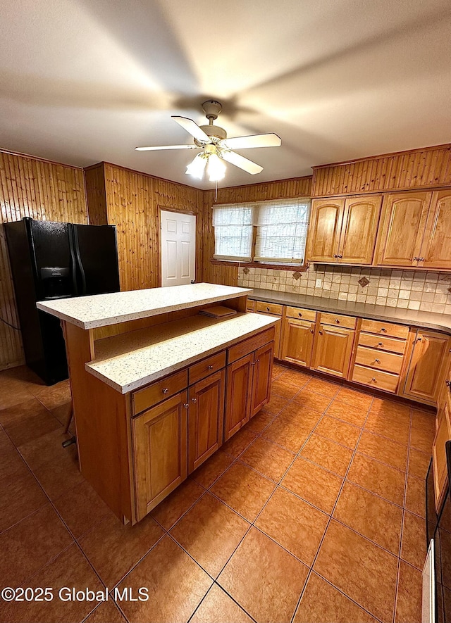 2618 Stanton St, Rotterdam, NY 12306 - kitchen featuring black fridge with ice dispenser, a kitchen island, a ceiling fan, tasteful backsplash, and brown cabinets