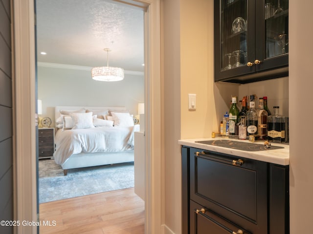 38 High Rock Ave Unit 4D, Saratoga Springs, NY 12866 - indoor dry bar featuring ornamental molding, light wood-style floors, decorative light fixtures, and a chandelier