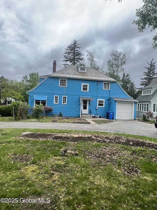 194 S Main Ave, Albany, NY 12208 - view of front of home featuring asphalt driveway, a garage, and a chimney