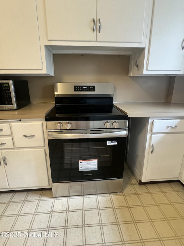 194 S Main Ave, Albany, NY 12208 - kitchen featuring stainless steel appliances, light countertops, light flooring, and white cabinetry