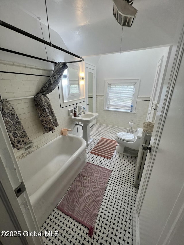 194 S Main Ave, Albany, NY 12208 - full bathroom featuring tile walls, a wainscoted wall, toilet, a tub, and a sink