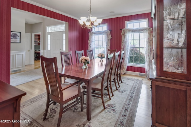 6 Copenhagen Ct, Colonie, NY 12047 - dining space with a chandelier, wallpapered walls, ornamental molding, plenty of natural light, and light wood finished floors