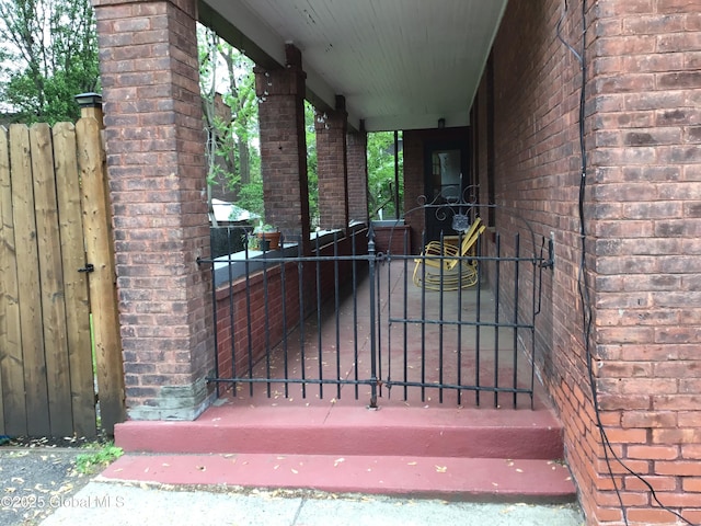 281 10th St, Troy, NY 12180 - view of exterior entry with brick siding, a gate, and an attached carport