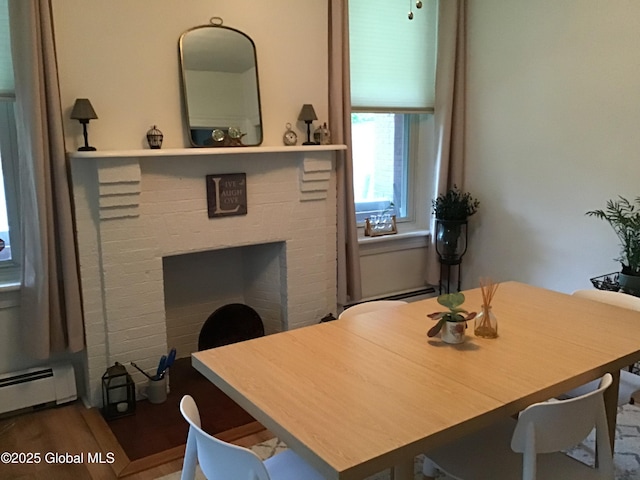 281 10th St, Troy, NY 12180 - dining area with a baseboard radiator, a fireplace, and wood finished floors