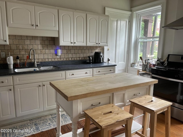 281 10th St, Troy, NY 12180 - kitchen featuring stainless steel range with gas stovetop, wooden counters, a sink, white cabinets, and light wood-style flooring