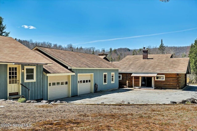 399 Loch Muller Rd, Schroon, NY 12870 - view of front of property with a chimney, entry steps, a shingled roof, an attached garage, and board and batten siding