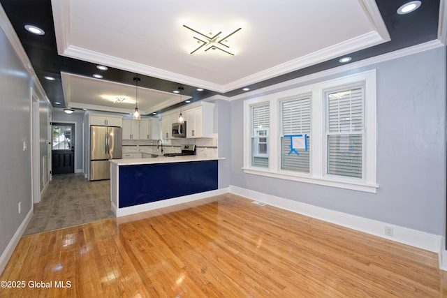 35 Wallace St, Scotia, NY 12302 - kitchen with appliances with stainless steel finishes, a tray ceiling, crown molding, light countertops, and light wood-type flooring