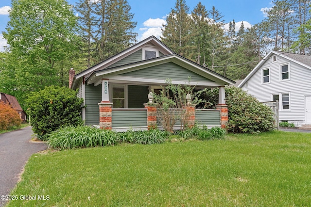 406 Northern Pines Rd, Wilton, NY 12831 - view of front of home featuring a porch, a front lawn, and a chimney