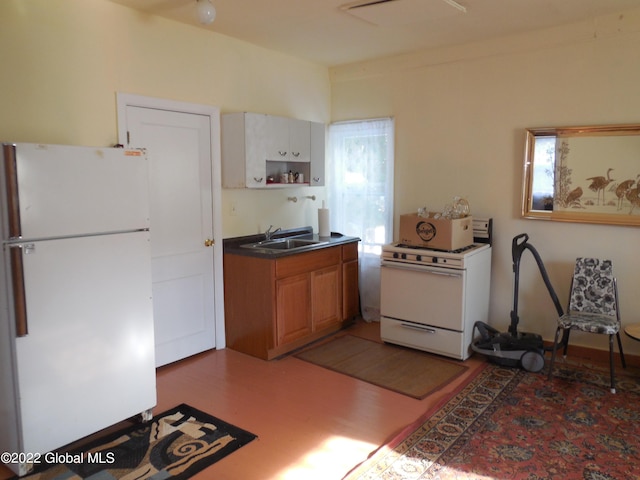 114 Washington St, Sharon Springs, NY 13459 - kitchen featuring white appliances, a sink, light wood-type flooring, brown cabinetry, and dark countertops