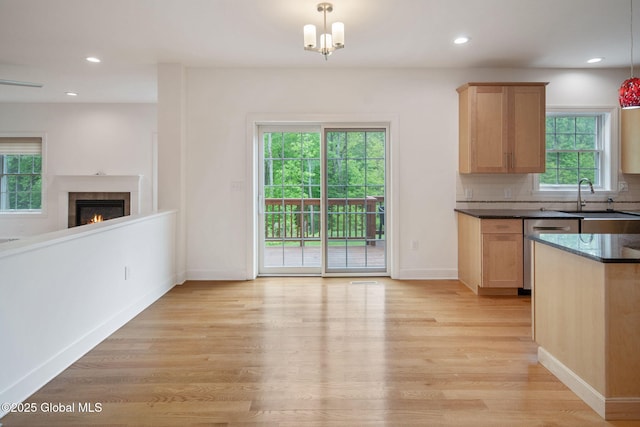 45 Tamarack Ln, Colonie, NY 12309 - kitchen with dishwasher, light wood-type flooring, light brown cabinetry, a warm lit fireplace, and a sink