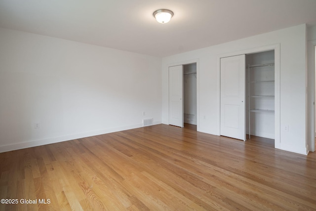 45 Tamarack Ln, Colonie, NY 12309 - unfurnished bedroom with multiple closets, light wood finished floors, and baseboards