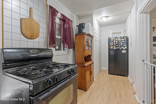 797 Eastern Ave, Schenectady, NY 12308 - kitchen with black appliances, light wood-type flooring, a textured ceiling, and baseboards