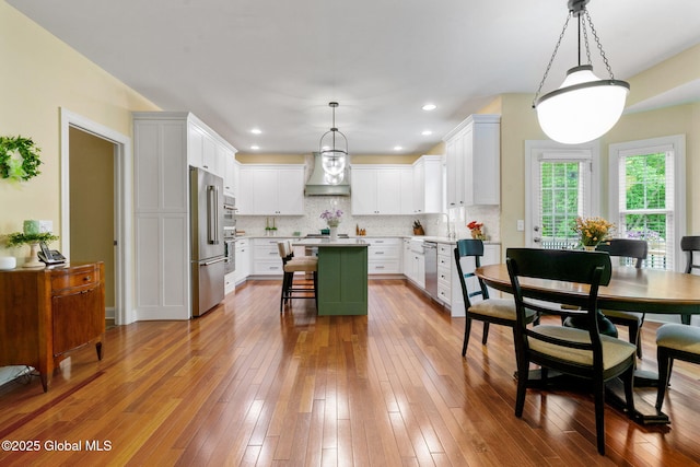 41 Tipperary Way, Clifton Park, NY 12019 - kitchen featuring stainless steel appliances, custom range hood, a center island, a kitchen bar, and light countertops