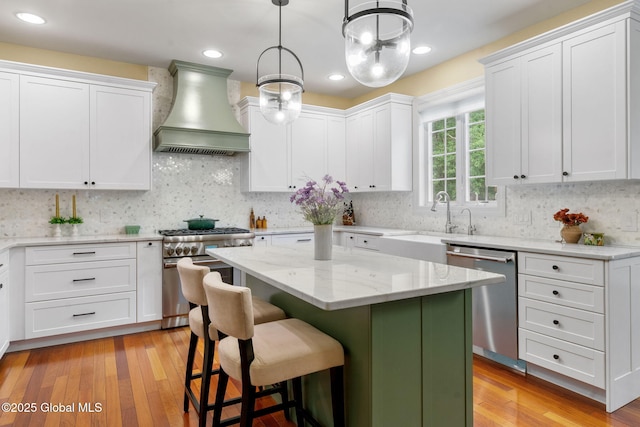 41 Tipperary Way, Clifton Park, NY 12019 - kitchen featuring appliances with stainless steel finishes, premium range hood, a center island, white cabinetry, and recessed lighting