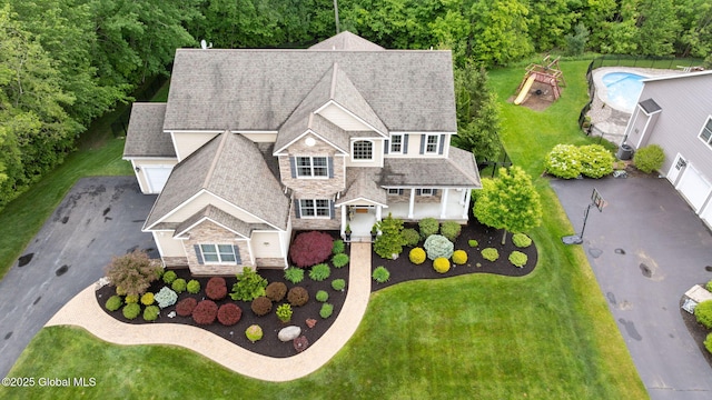 41 Tipperary Way, Clifton Park, NY 12019 - view of front facade with stone siding, driveway, a shingled roof, an attached garage, and an outdoor pool