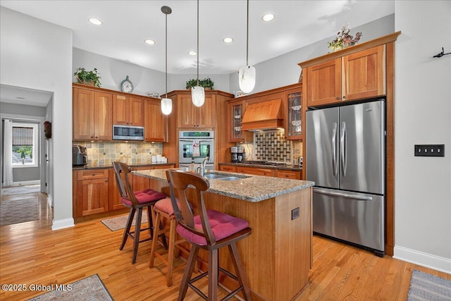 19 Hidden Farm Ln, Halfmoon, NY 12118 - kitchen featuring appliances with stainless steel finishes, brown cabinetry, premium range hood, and recessed lighting