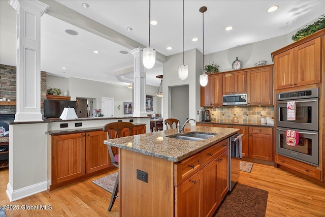 19 Hidden Farm Ln, Halfmoon, NY 12118 - kitchen with appliances with stainless steel finishes, a sink, ornate columns, a kitchen breakfast bar, and tasteful backsplash