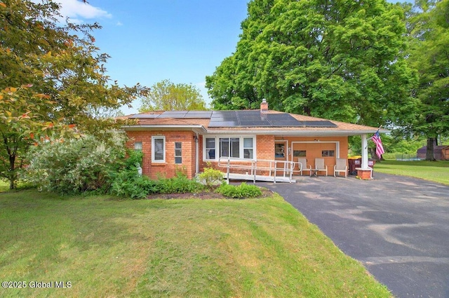 8 Adams Ave, East Greenbush, NY 12144 - ranch-style house featuring a front lawn, roof mounted solar panels, a chimney, and brick siding