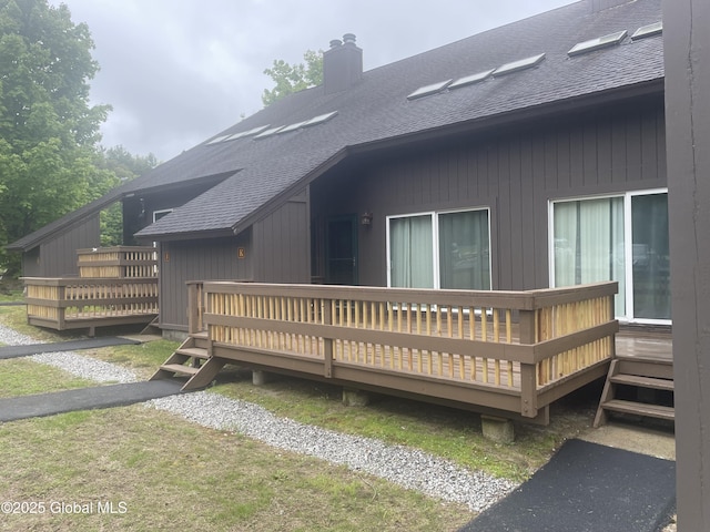 11K Overlook Ln, Warrensburg, NY 12817 - view of side of home featuring a shingled roof, a chimney, and a wooden deck