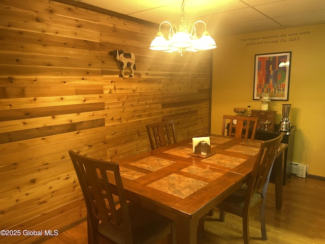 11K Overlook Ln, Warrensburg, NY 12817 - dining room with a chandelier, wooden walls, a baseboard radiator, and wood finished floors