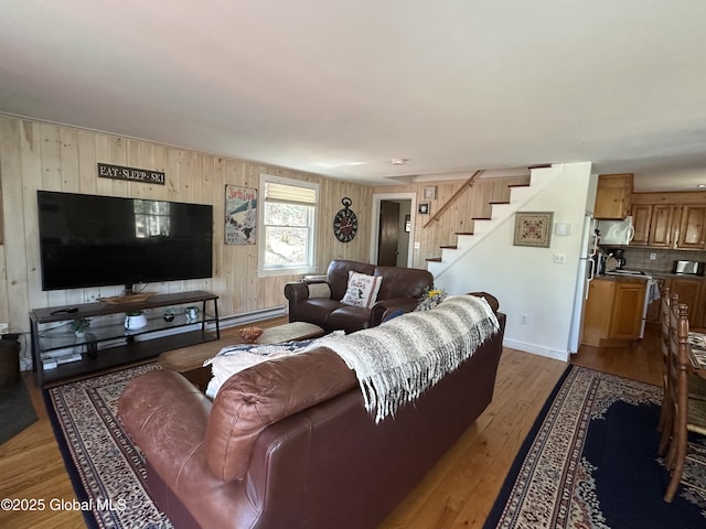 34 Park Rd, Johnsburg, NY 12843 - living area with stairs, light wood-style floors, wood walls, and baseboards