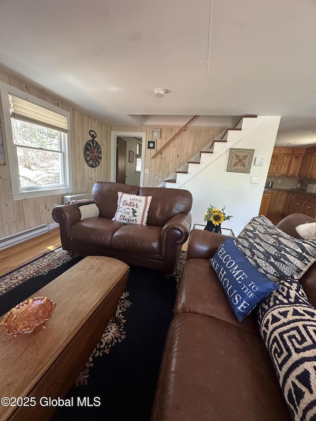 34 Park Rd, Johnsburg, NY 12843 - living room featuring stairway, wooden walls, wood finished floors, and a baseboard heating unit
