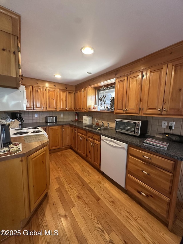 34 Park Rd, Johnsburg, NY 12843 - kitchen with white dishwasher, a sink, light wood-style flooring, brown cabinets, and decorative backsplash