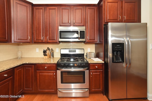 509 Lois Ln, Niskayuna, NY 12304 - kitchen with appliances with stainless steel finishes, reddish brown cabinets, tasteful backsplash, and light stone countertops