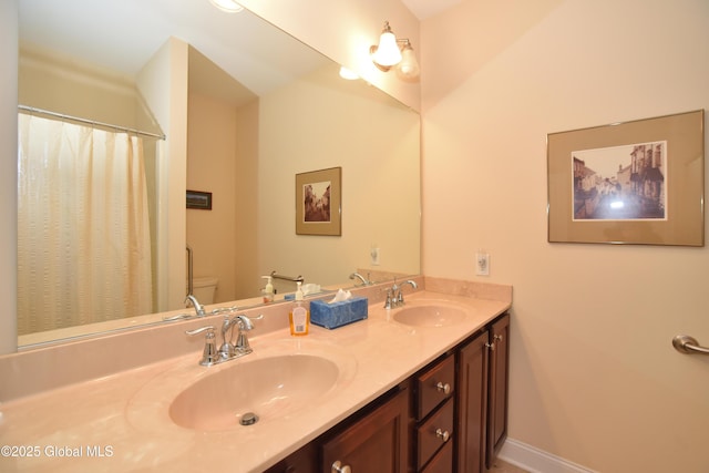 509 Lois Ln, Niskayuna, NY 12304 - bathroom featuring toilet, double vanity, baseboards, and curtained shower