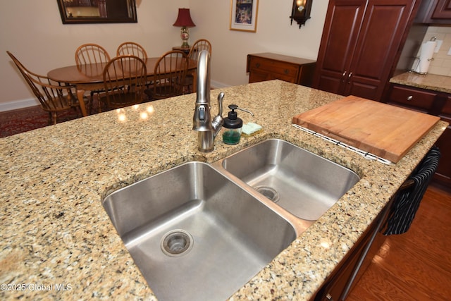 509 Lois Ln, Niskayuna, NY 12304 - kitchen featuring a sink, baseboards, light stone counters, dark wood-style floors, and decorative backsplash