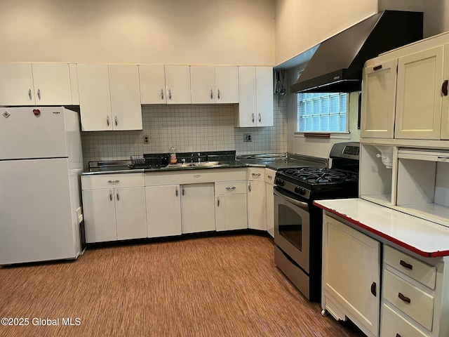 1466 3rd St, Rensselaer, NY 12144 - kitchen with freestanding refrigerator, gas stove, white cabinetry, and backsplash
