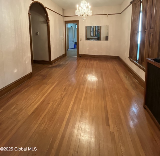 1466 3rd St, Rensselaer, NY 12144 - spare room with hardwood / wood-style flooring, a chandelier, and arched walkways