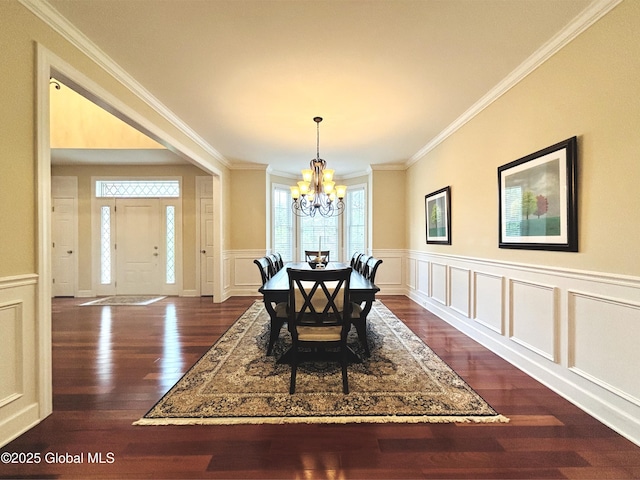 779 Waldens Pond, Guilderland, NY 12203 - dining room with a chandelier, crown molding, a decorative wall, dark wood-type flooring, and a wainscoted wall