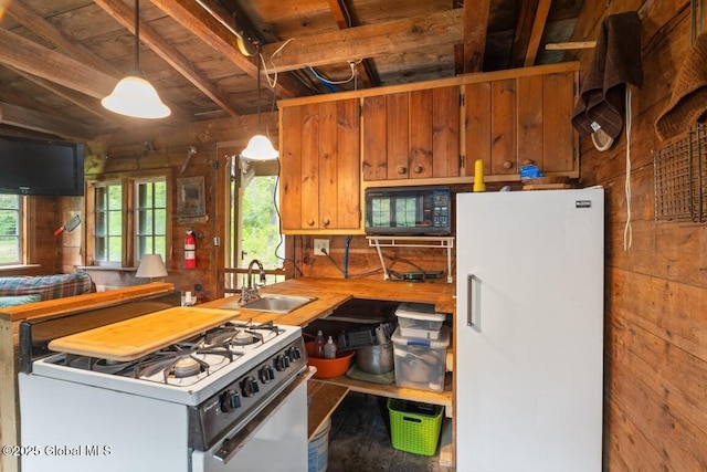 429 Posson Hill Rd, Middleburgh, NY 12122 - kitchen featuring white appliances, a sink, wood walls, pendant lighting, and brown cabinetry