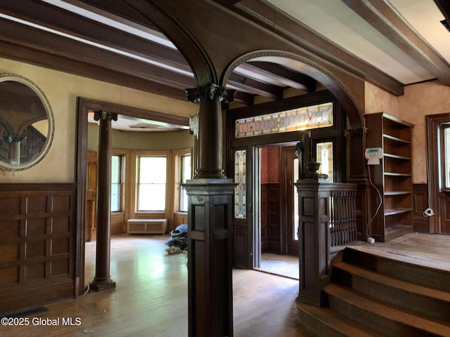1077 University Pl, Schenectady, NY 12308 - staircase with decorative columns, beamed ceiling, a decorative wall, wainscoting, and wood finished floors