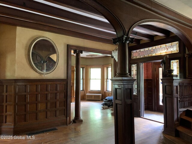 1077 University Pl, Schenectady, NY 12308 - entryway featuring ornate columns, a decorative wall, beam ceiling, a wainscoted wall, and wood finished floors
